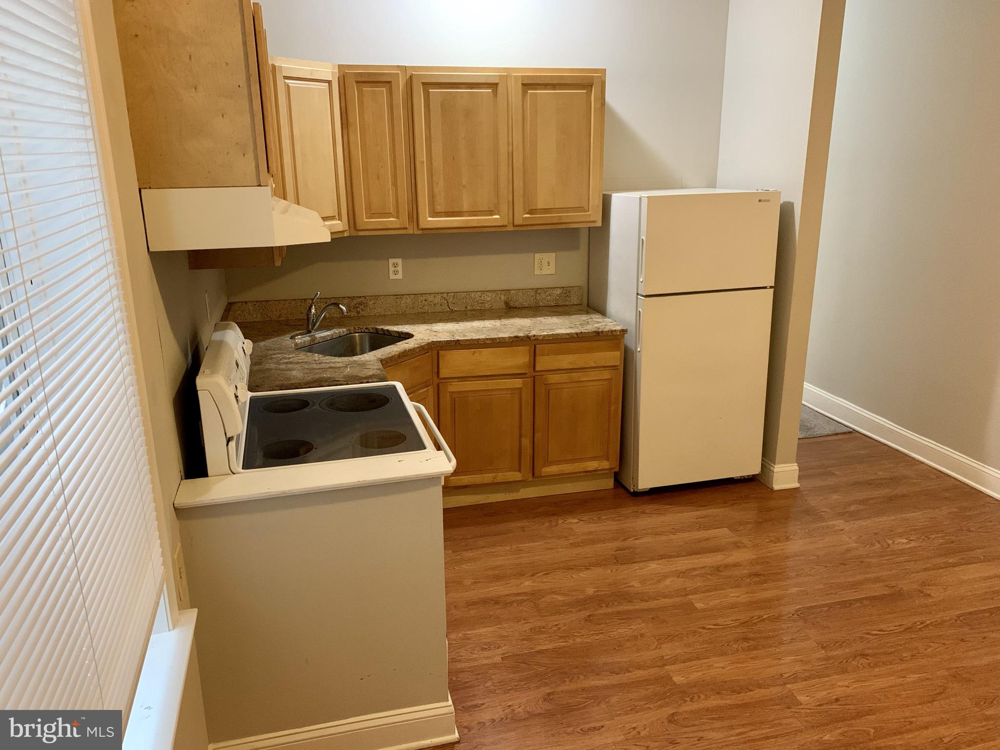 4439 Chestnut Street, Unit 1R Philadelphia, PA 19104 - Photo 5 of 22 a kitchen with a refrigerator sink stove and cabinets