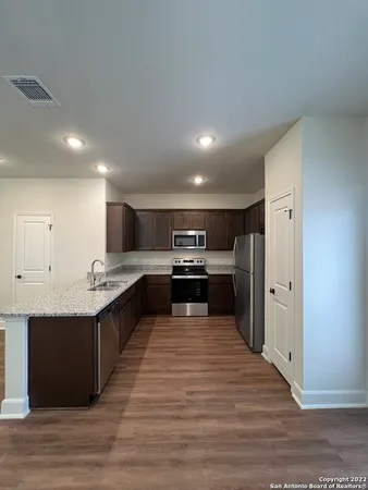 a large kitchen with stainless steel appliances granite countertop a large counter top and a stove