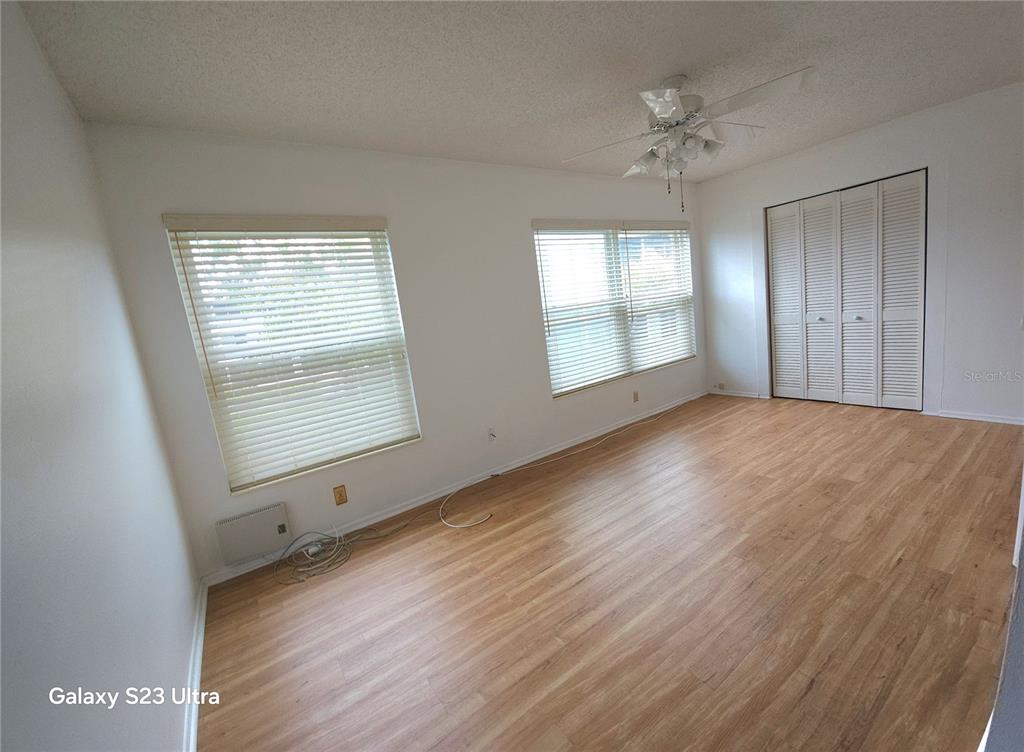 2386 Sumatran Way, Unit 44 Clearwater, FL 33763 - Photo 12 of 25 a view of an empty room with wooden floor and a window