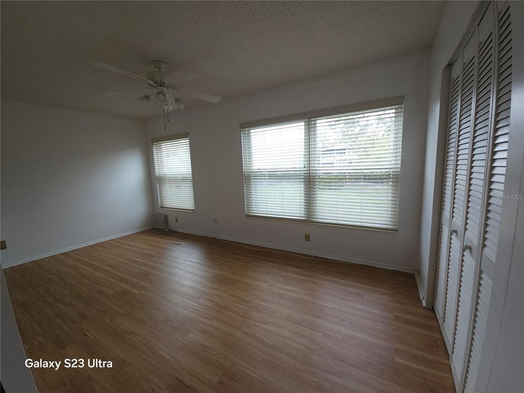 2386 Sumatran Way, Unit 44 Clearwater, FL 33763 - Photo 13 of 25 an empty room with wooden floor and windows