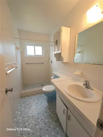 a bathroom with a sink a toilet and shower