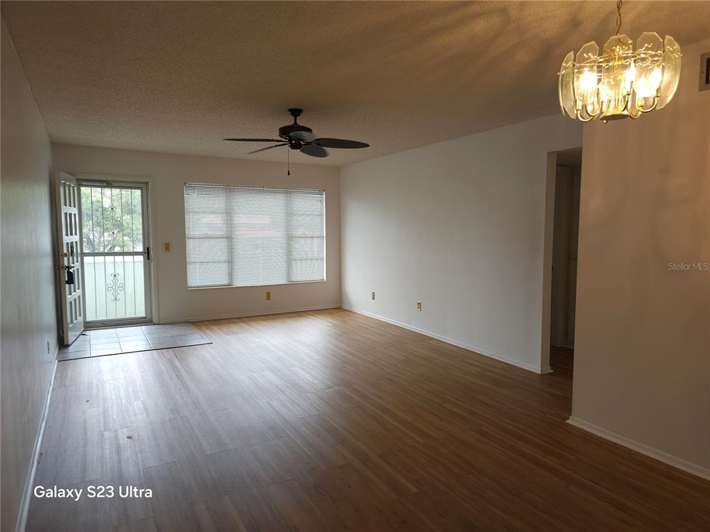 2386 Sumatran Way, Unit 44 Clearwater, FL 33763 - Photo 6 of 25 an empty room with wooden floor chandelier and windows