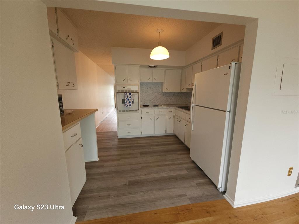 2386 Sumatran Way, Unit 44 Clearwater, FL 33763 - Photo 8 of 25 a kitchen with white cabinets and white appliances