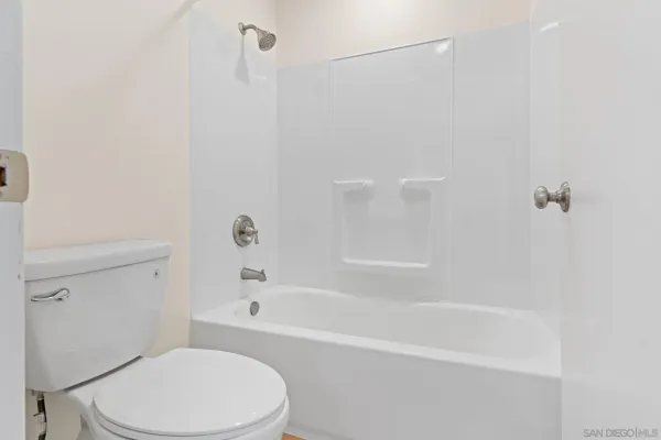 a white toilet and tub sitting next to a bathroom sink