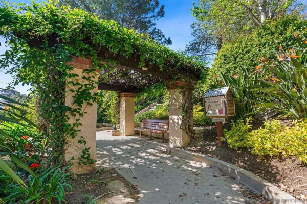 a view of a street with potted plants and large trees