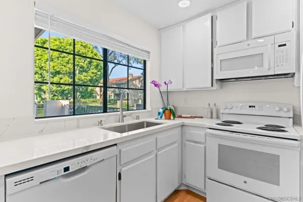 a kitchen with white cabinets and white appliances