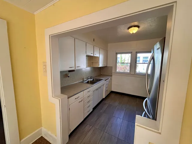 a kitchen with stainless steel appliances a stove a sink and a hard wood floor