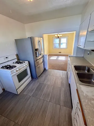 a kitchen with granite countertop white cabinets and white appliances