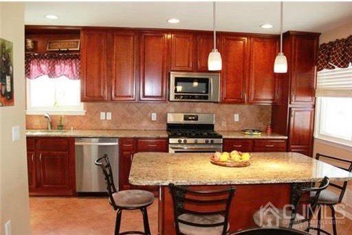 116 Prentice Avenue South River, NJ 08882 - Photo 11 of 27 a kitchen with a stove a sink a microwave and wooden cabinets