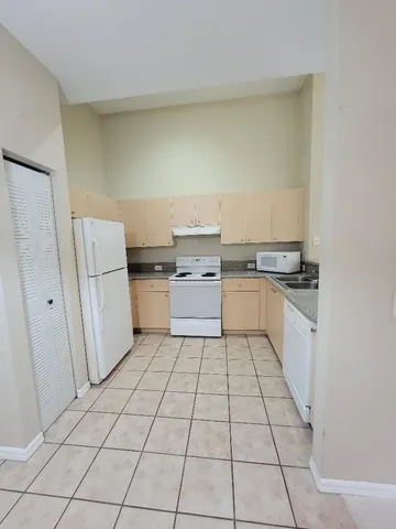 a kitchen with a stove top oven and white cabinets