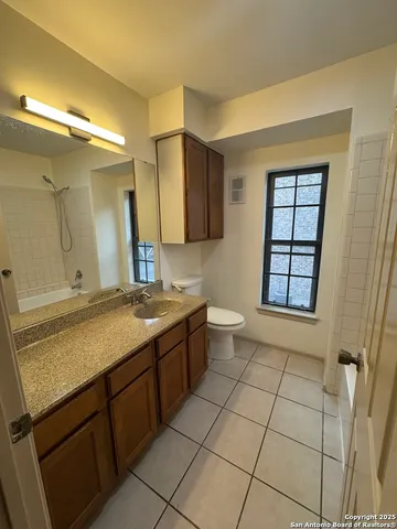 a bathroom with a granite countertop sink toilet and mirror