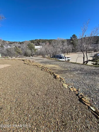 a view of a dry yard with wooden fence