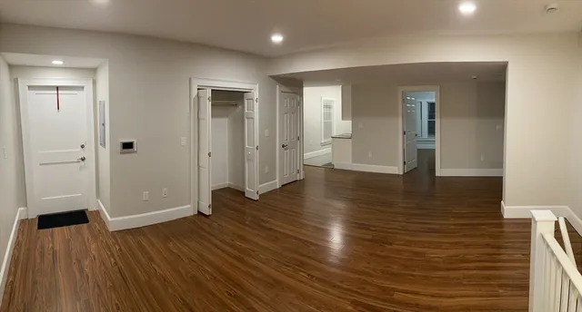 an empty room with wooden floor and entrance