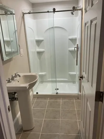 a bathroom with a shower and a sink
