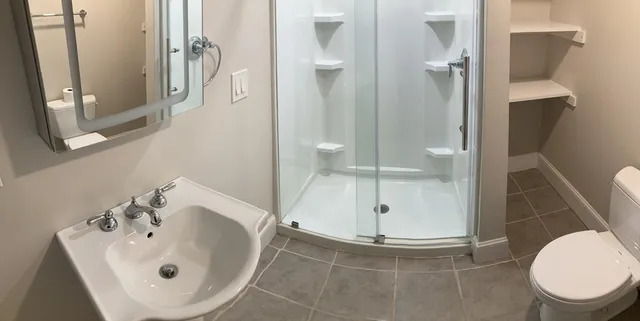 a bathroom with a sink and mirror with toilet