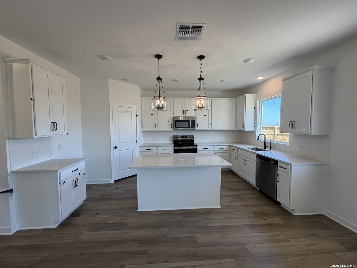 410 Nottabi Road Adkins, TX 78101 - Photo 15 of 33 a large kitchen with stainless steel appliances kitchen island granite countertop a stove a sink and white cabinets
