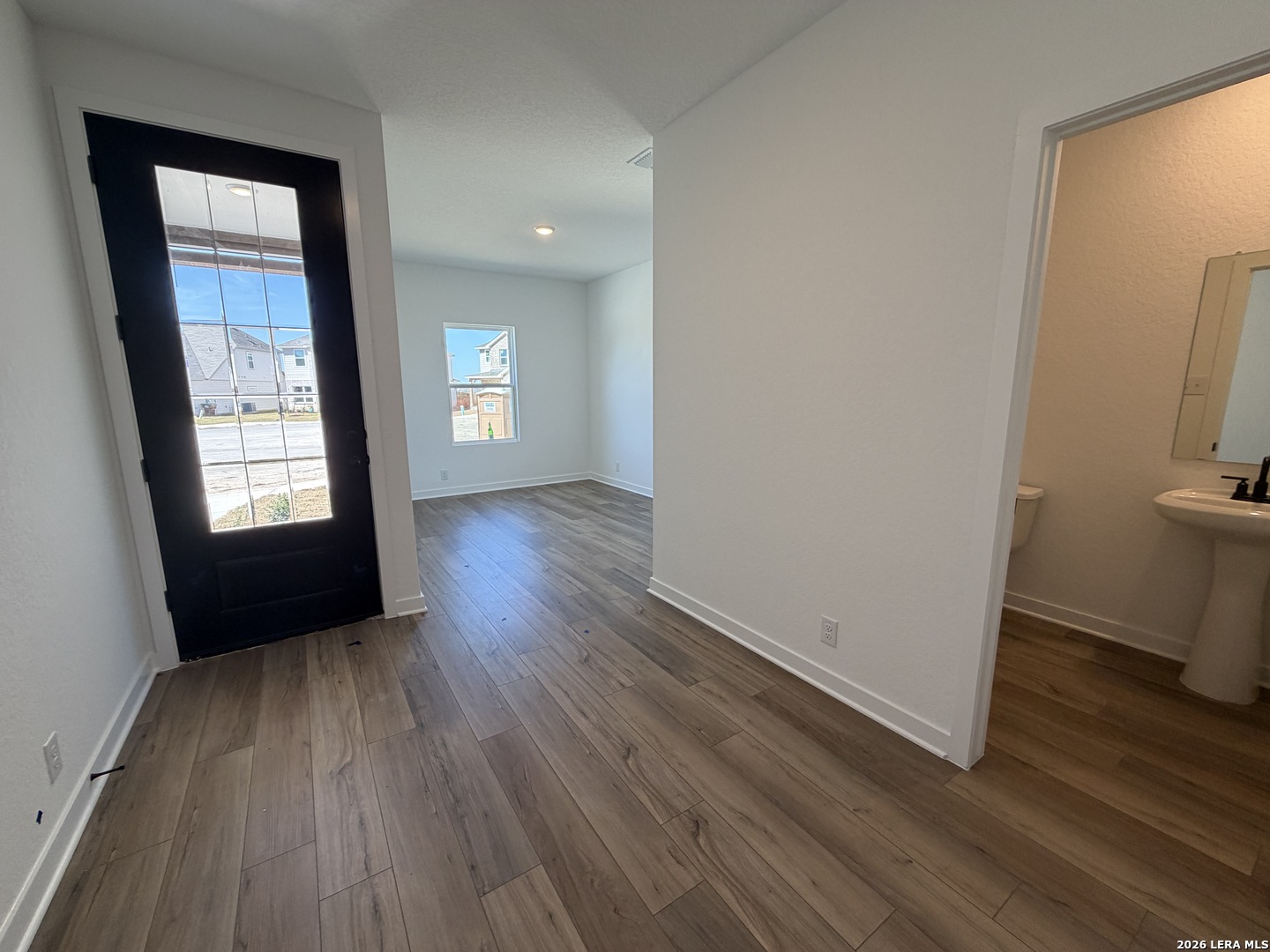 410 Nottabi Road Adkins, TX 78101 - Photo 10 of 33 an empty room with wooden floor and windows