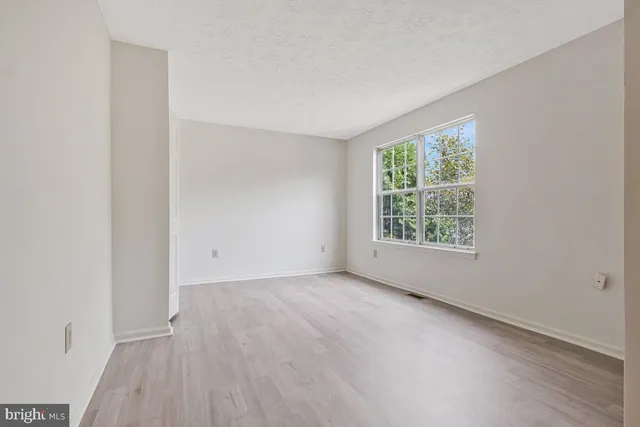a view of empty room with wooden floor and fireplace