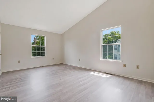 an empty room with wooden floor and a window