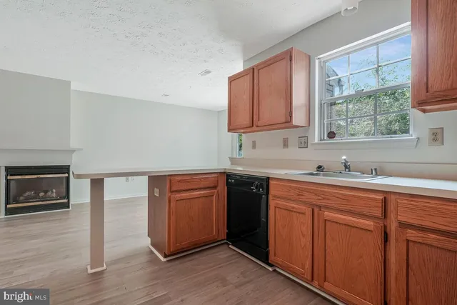 a kitchen with stainless steel appliances granite countertop a sink a stove cabinets and wooden floor