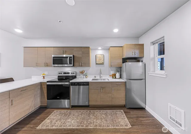 a kitchen with stainless steel appliances granite countertop a refrigerator stove top oven and sink