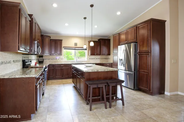 a kitchen with stainless steel appliances granite countertop wooden cabinets a stove top oven a sink and dishwasher