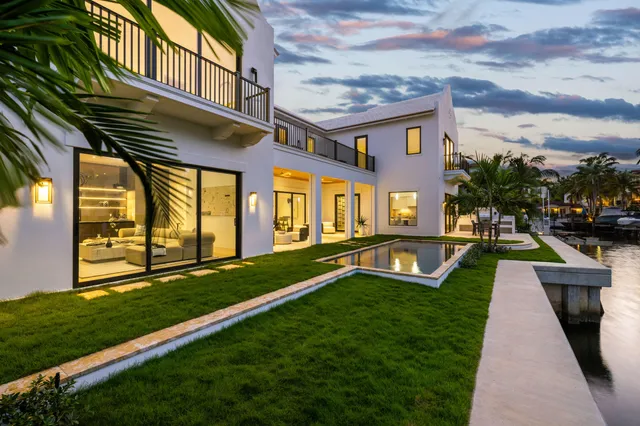 a view of a swimming pool with a fountain in front of a house