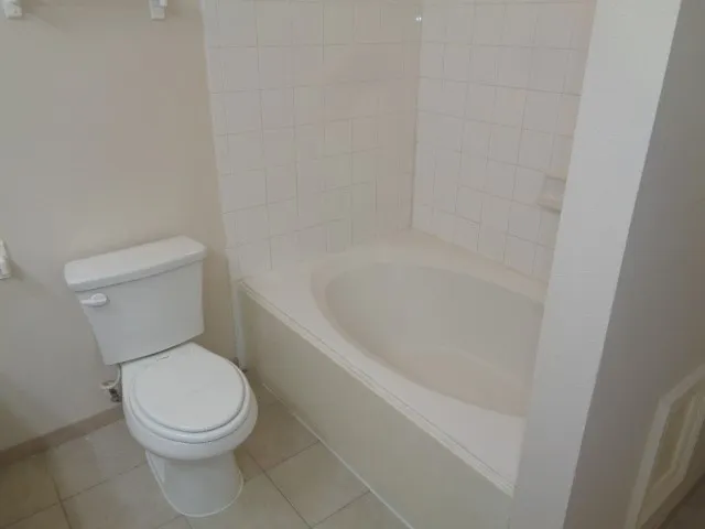 a white toilet sitting next to a bath tub