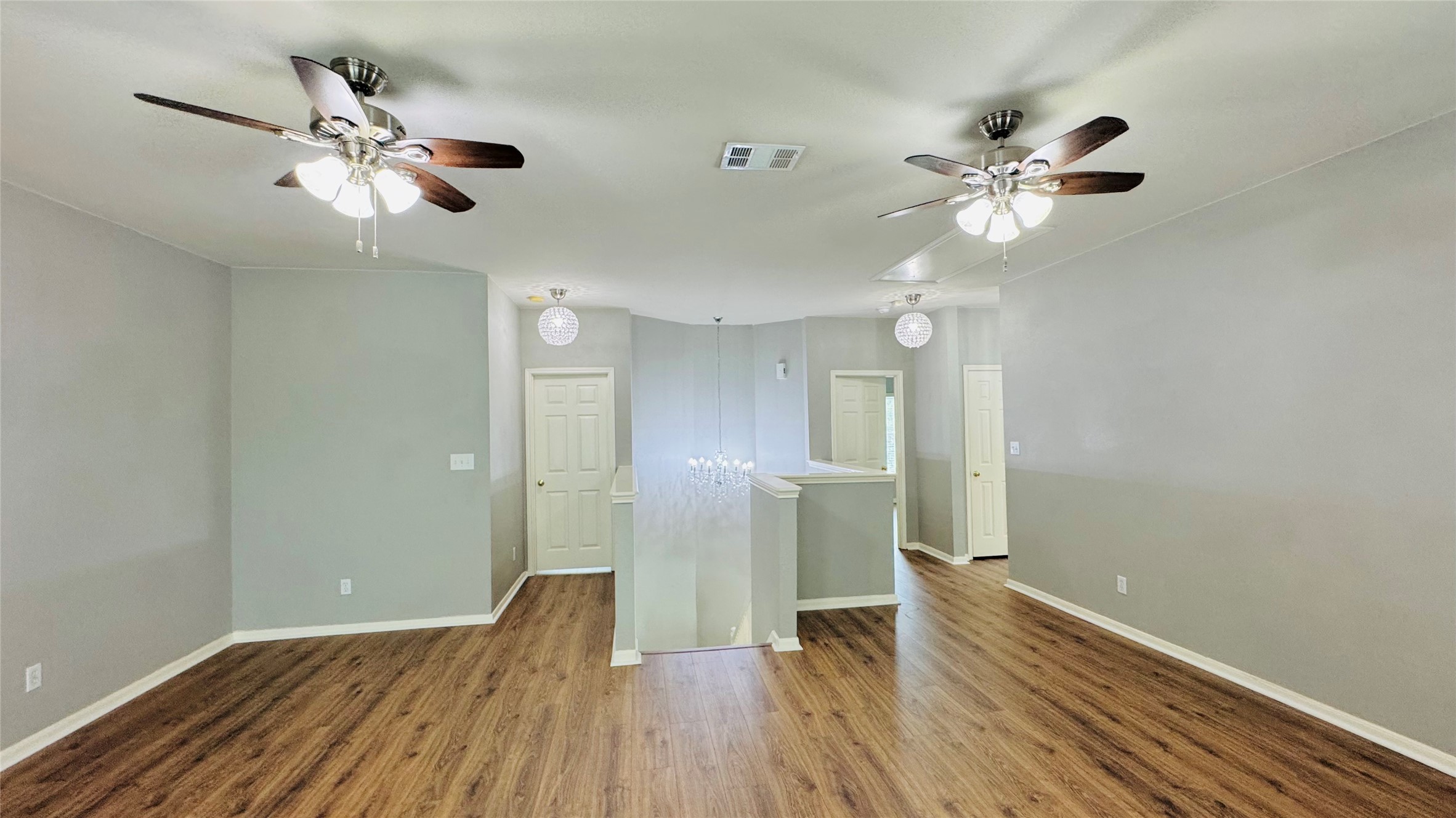 401 Witte Road Kyle, TX 78640 - Photo 5 of 9 Upper level-Rich wood flooring grounds this airy living space, illuminated by modern ceiling fans and elegant lighting.