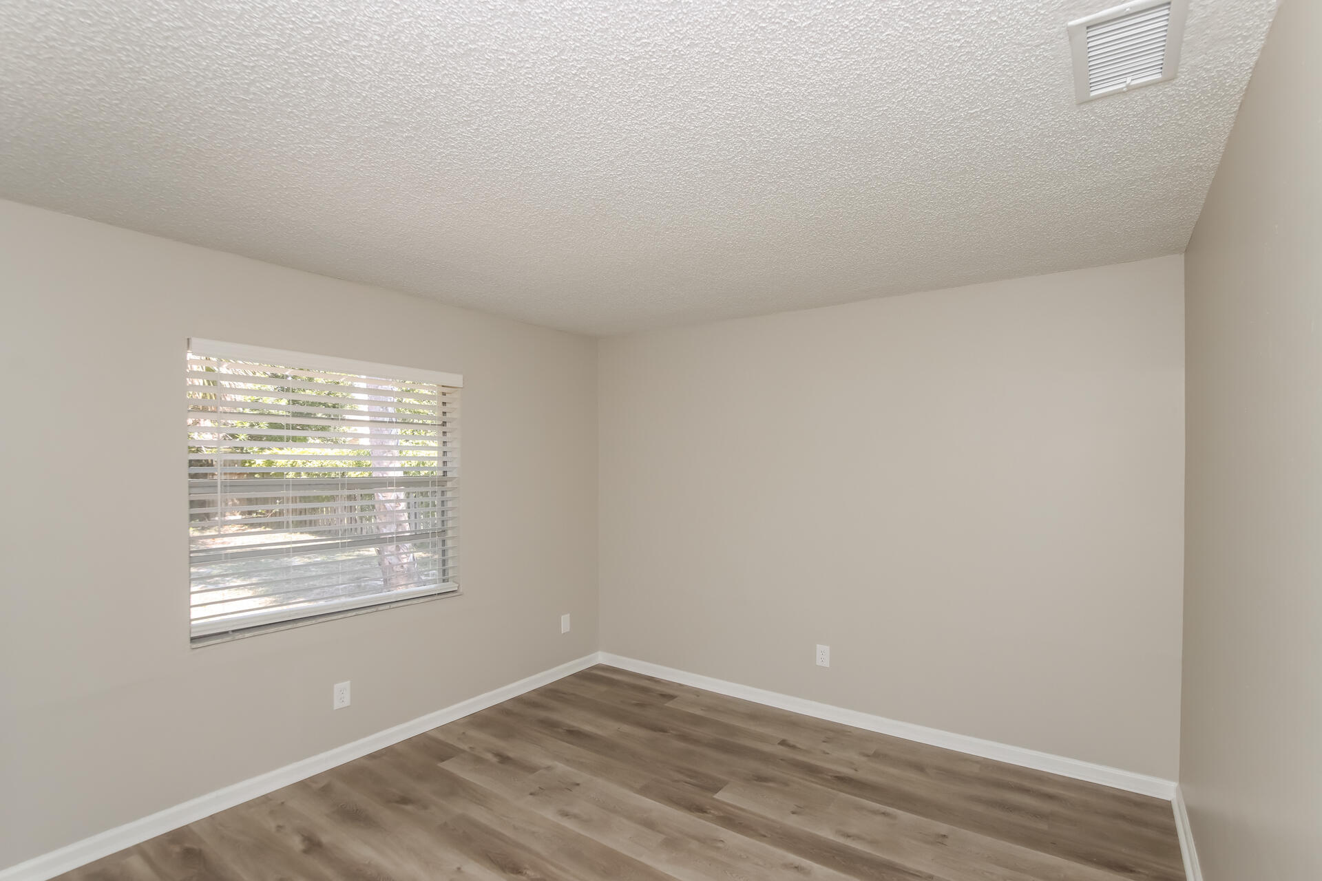 3386 Jay Tee Drive Melbourne, FL 32901 - Photo 11 of 16 a view of an empty room with wooden floor and a window