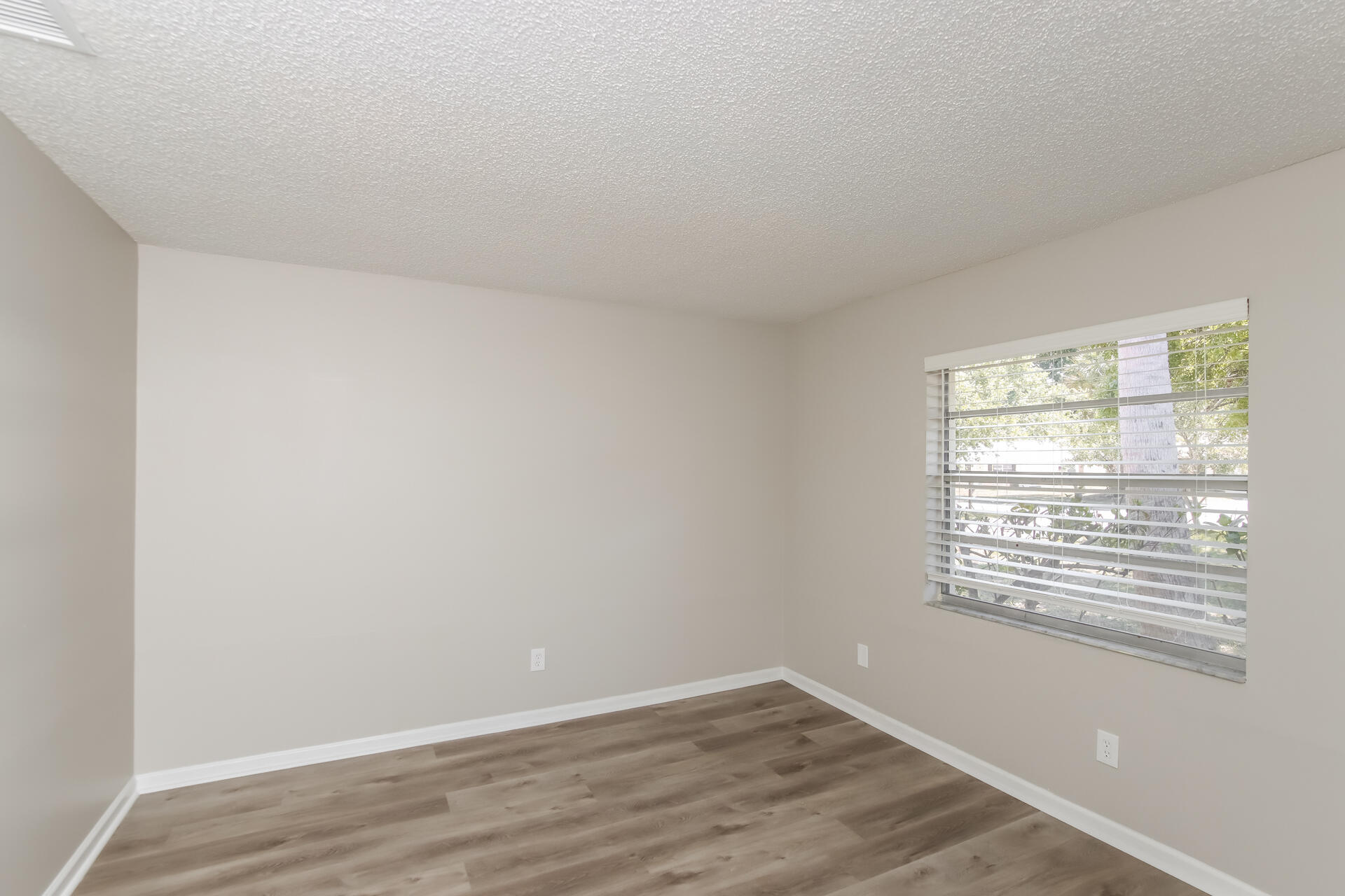 3386 Jay Tee Drive Melbourne, FL 32901 - Photo 12 of 16 a view of an empty room with wooden floor and a window