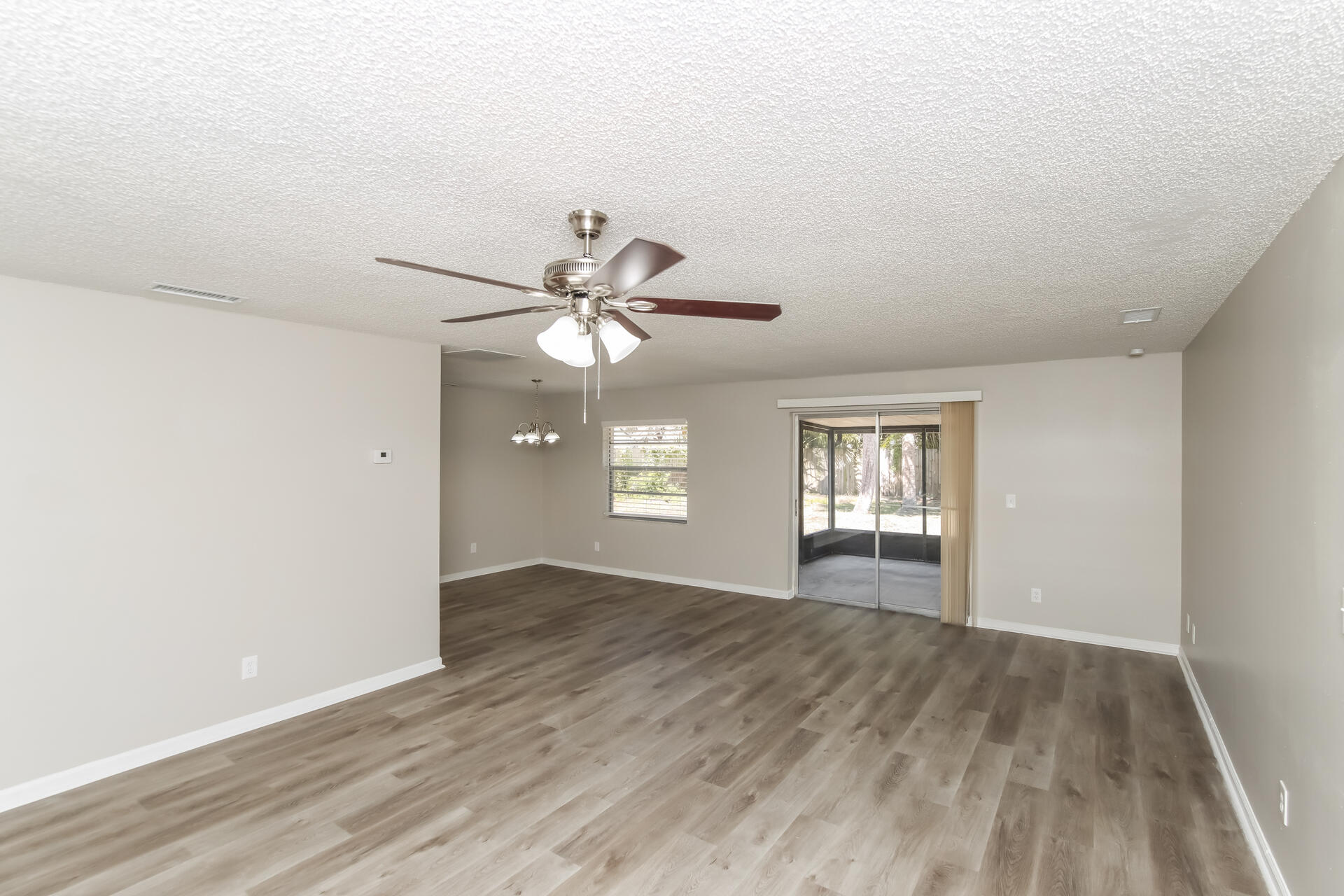 3386 Jay Tee Drive Melbourne, FL 32901 - Photo 3 of 16 a view of an empty room with window and wooden floor