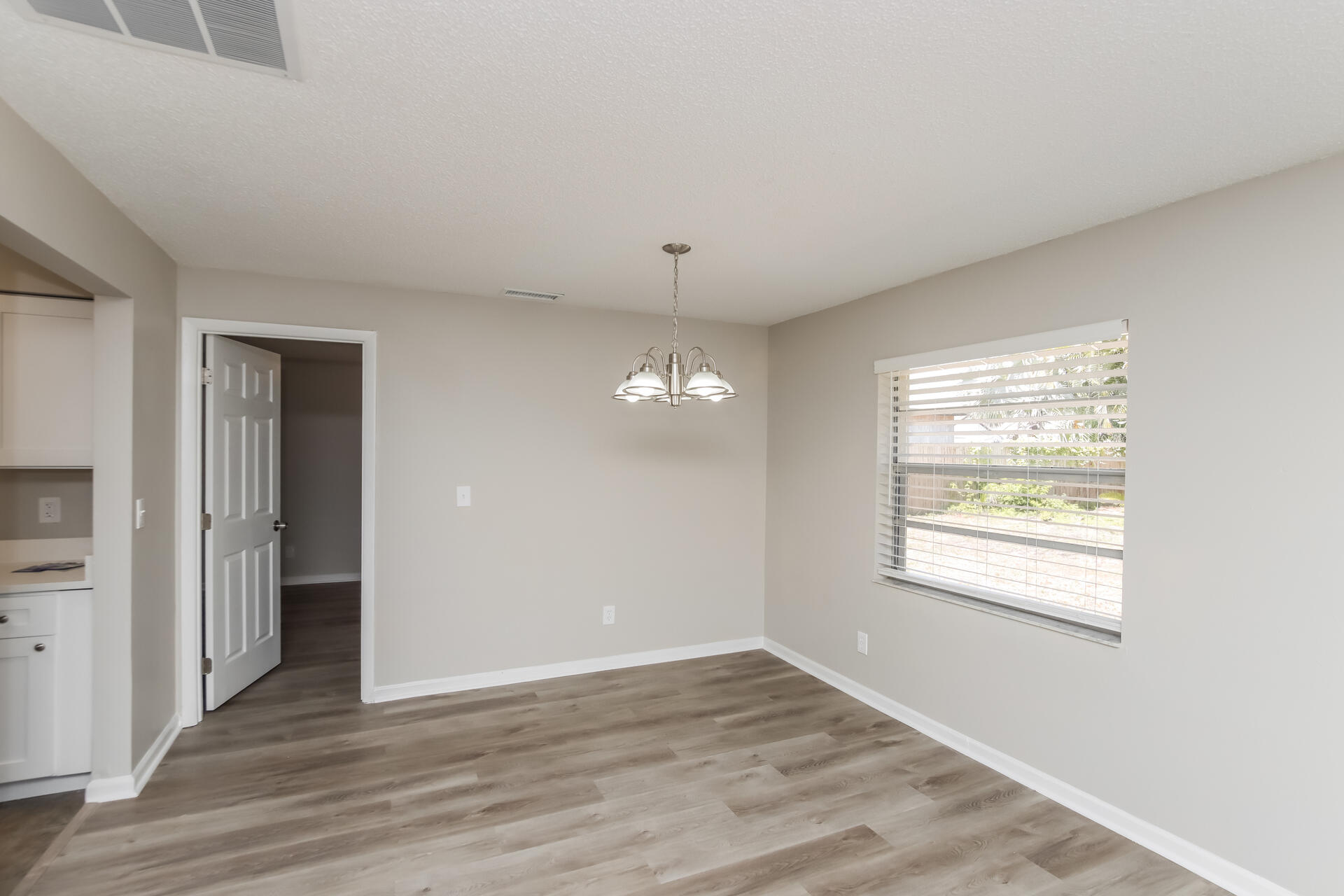 3386 Jay Tee Drive Melbourne, FL 32901 - Photo 5 of 16 a view of an empty room with wooden floor and a window