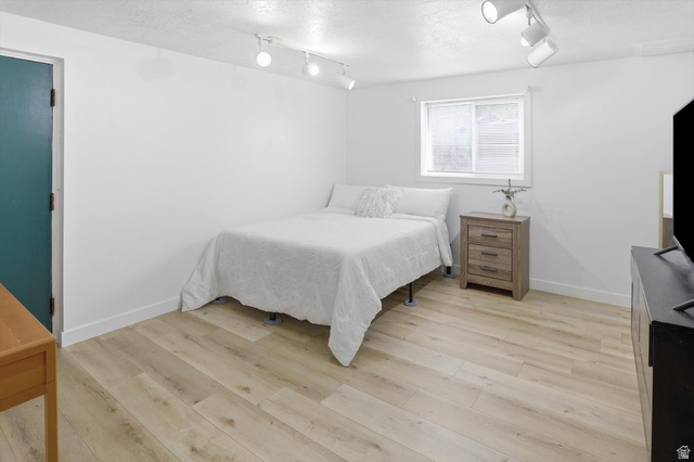 5108 South 2000th Street West Roy, UT 84067 - Photo 39 of 61 Bedroom featuring light wood-type flooring, track lighting, and a textured ceiling
