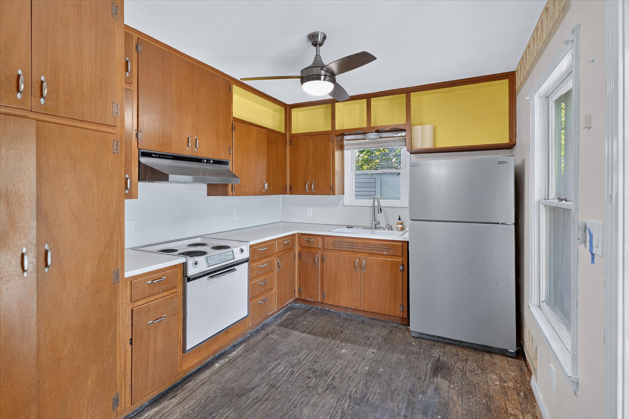 5701 Link Avenue Austin, TX 78752 - Photo 4 of 7 a kitchen with stainless steel appliances granite countertop a refrigerator a sink dishwasher a stove with white cabinets and wooden floor