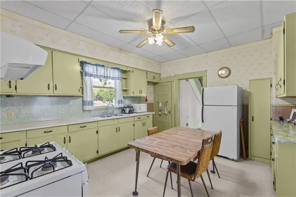 a kitchen with cabinets a sink a counter and chairs