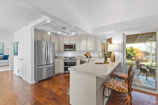 a kitchen with refrigerator a stove and wooden floor
