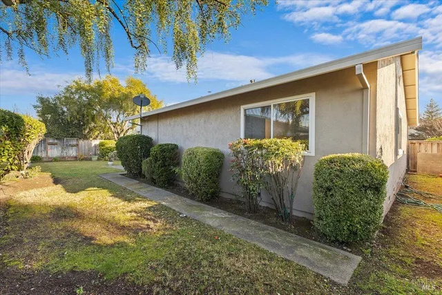 a view of a white house with a yard and sitting area