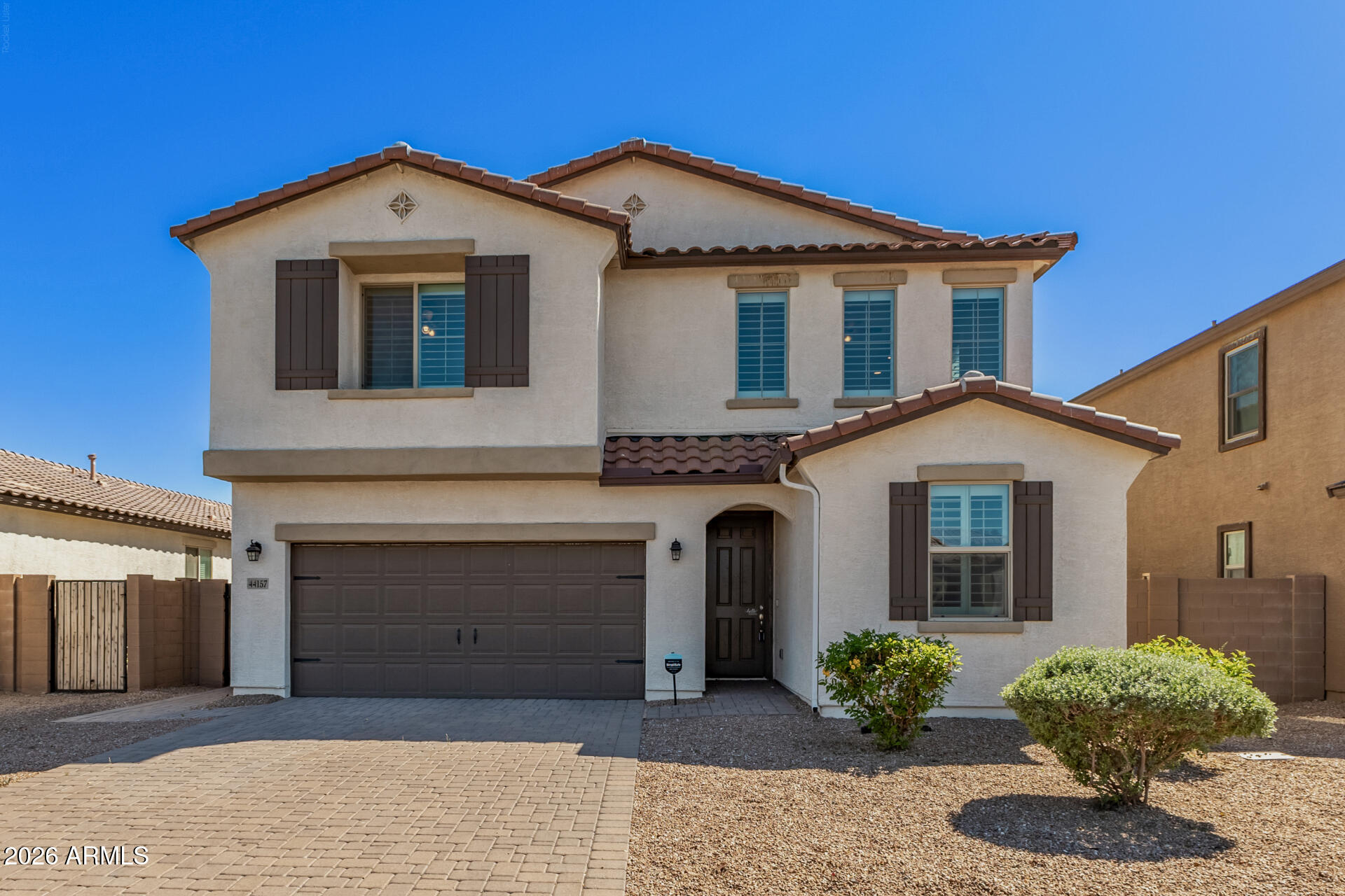 a front view of a house with a garden and plants