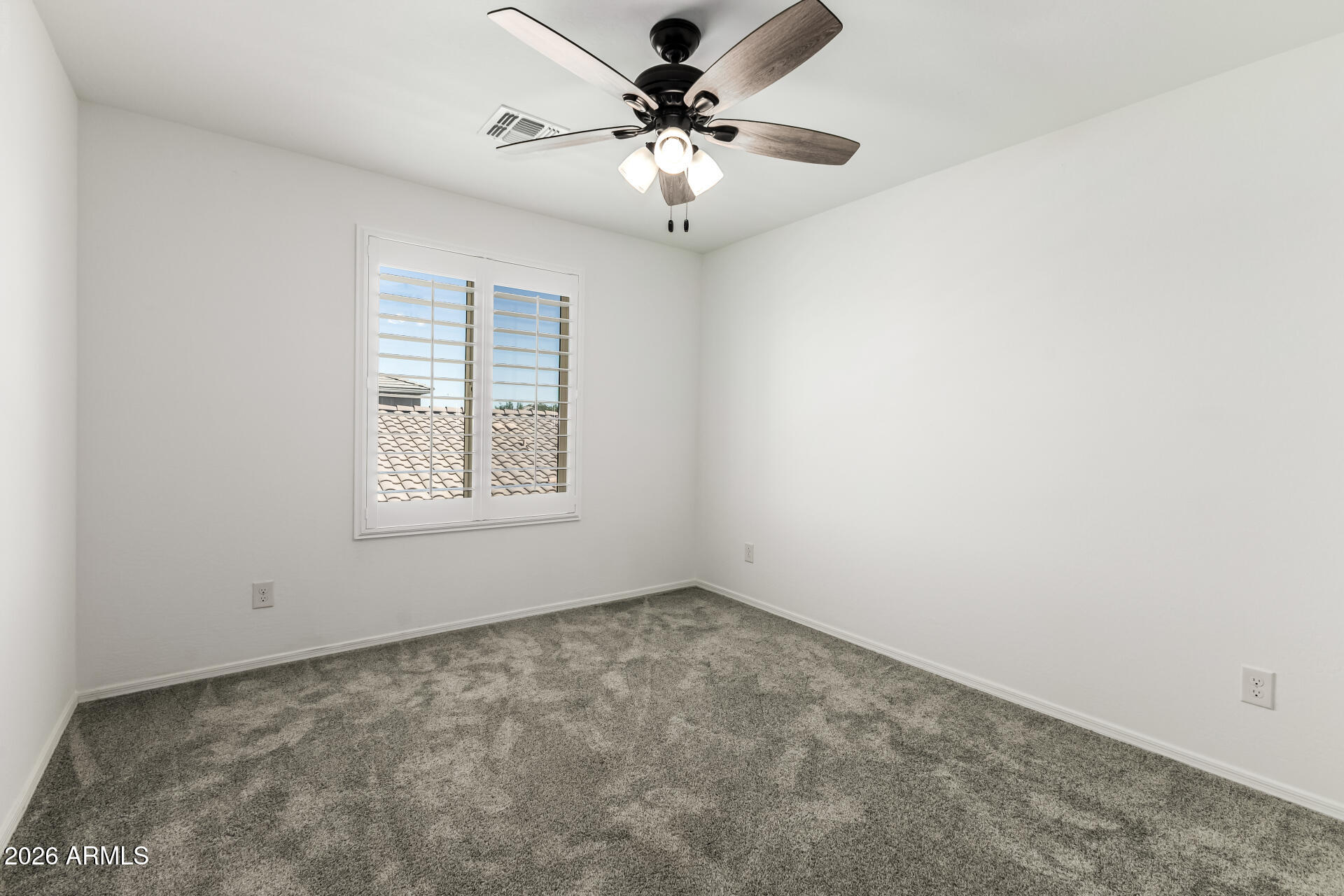 44157 West Palo Olmo Road Maricopa, AZ 85138 - Photo 27 of 34 an empty room with a chandelier fan and windows