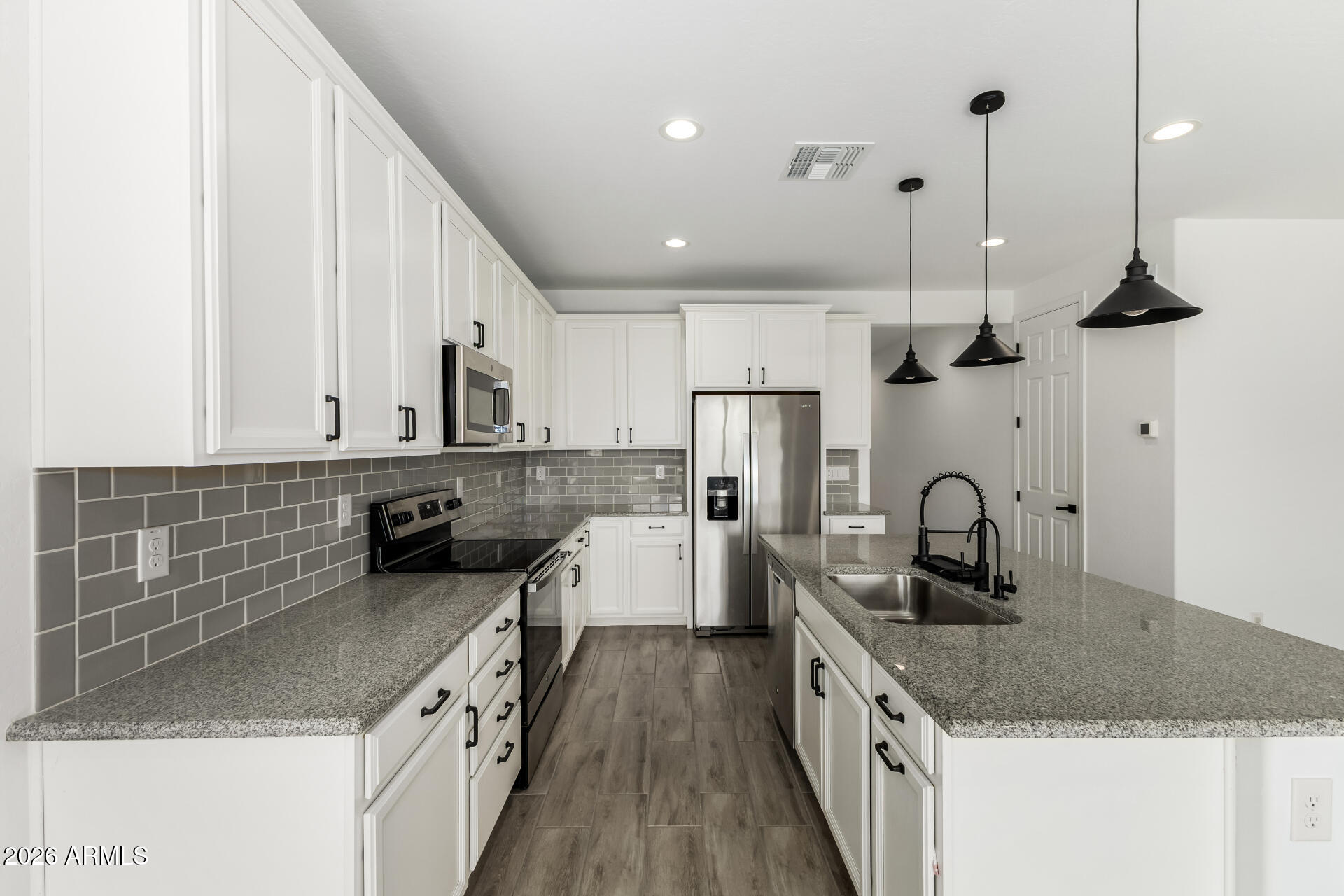 44157 West Palo Olmo Road Maricopa, AZ 85138 - Photo 9 of 34 a kitchen with stainless steel appliances granite countertop a sink a stove and a wooden floors