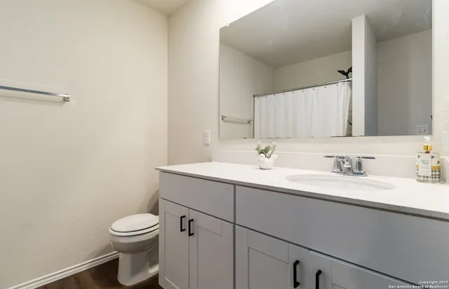 a bathroom with a toilet sink a mirror and vanity