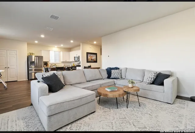 a living room with furniture and kitchen view