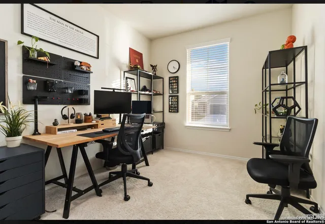 a view of a workspace with furniture and a window