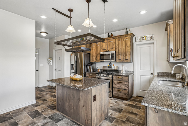 203 North 1900th Street West Mapleton, UT 84664 - Photo 9 of 48 Kitchen featuring a center island with a granite-style countertop, stainless steel appliances, recessed lighting, wood-finish cabinetry, and a pot rack with pendant lighting