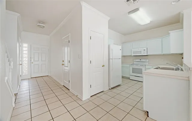 a view of a kitchen with white cabinets