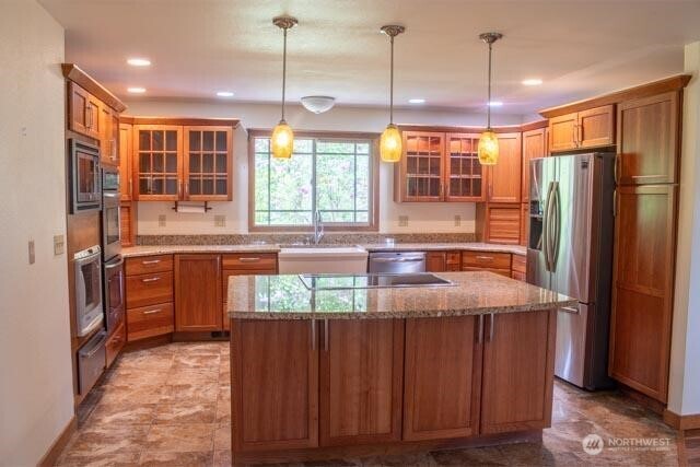 9844 173rd Avenue Southwest Rochester, WA 98579 - Photo 6 of 38 a kitchen with stainless steel appliances granite countertop a refrigerator a sink dishwasher a stove a dining table and chairs with wooden floor