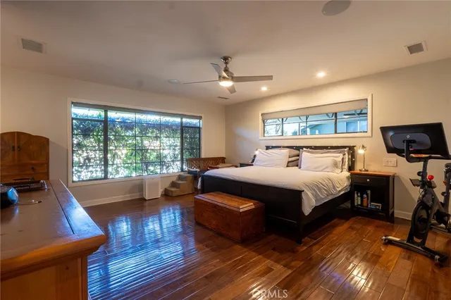 a bedroom with a bed a couch and large window