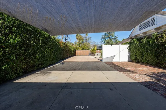 a patio with table and chairs and potted plants