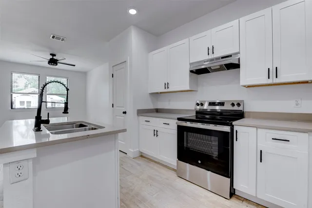 a kitchen with stainless steel appliances granite countertop a sink stove and cabinets